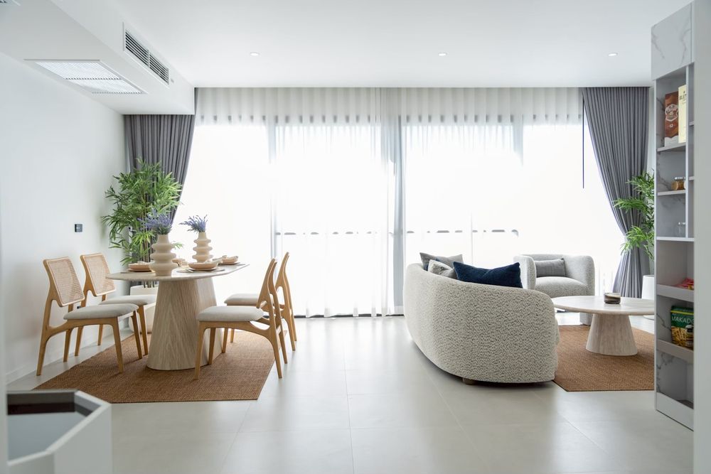 Furnished living and dining room with sheer curtains and soft daylight